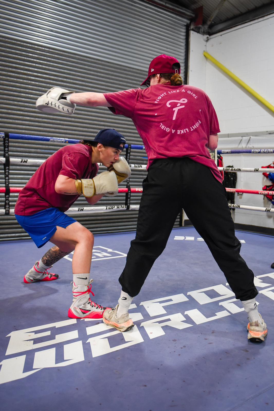 Savannah Marshall on the pads with a girl ducking under a punch